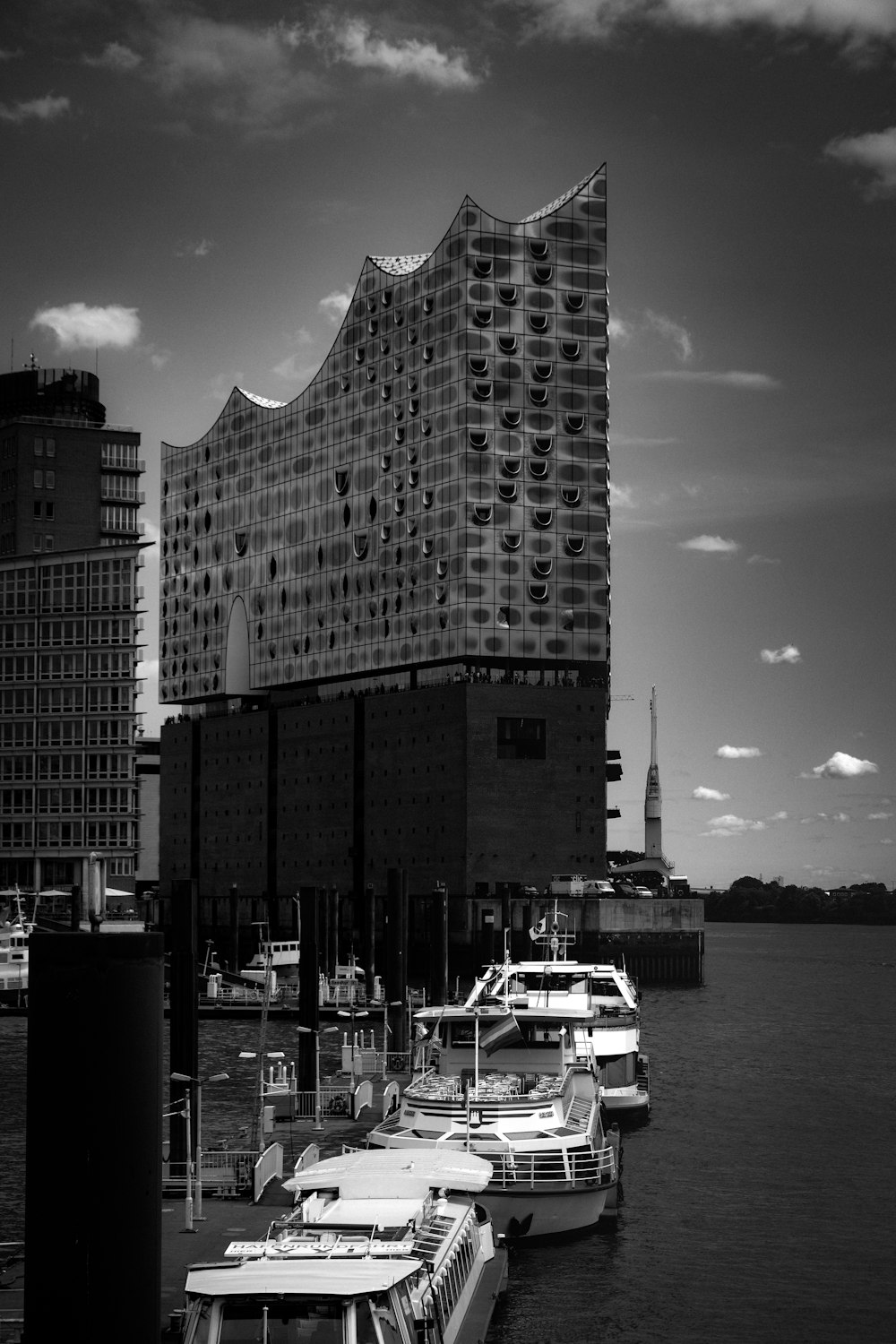 Foto en escala de grises de un edificio de gran altura cerca del cuerpo de agua