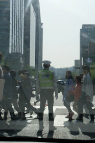 Close-up of a certified traffic controller communicating with a walkie-talkie on a busy street.