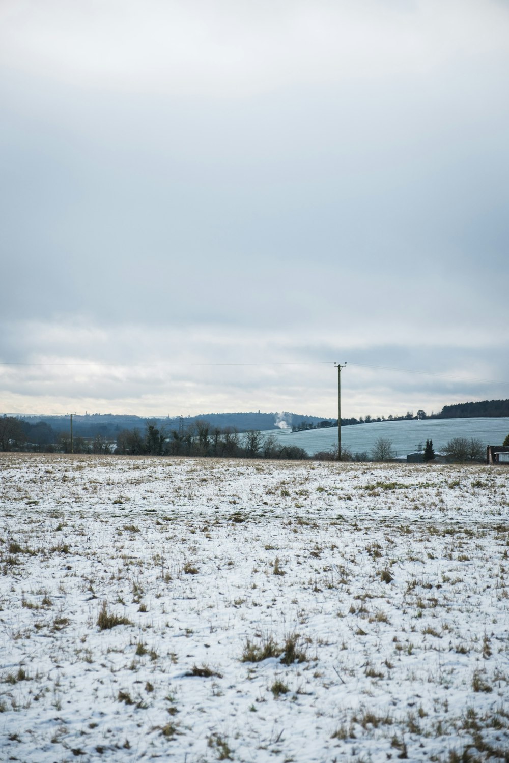 snow covered field near body of water during daytime