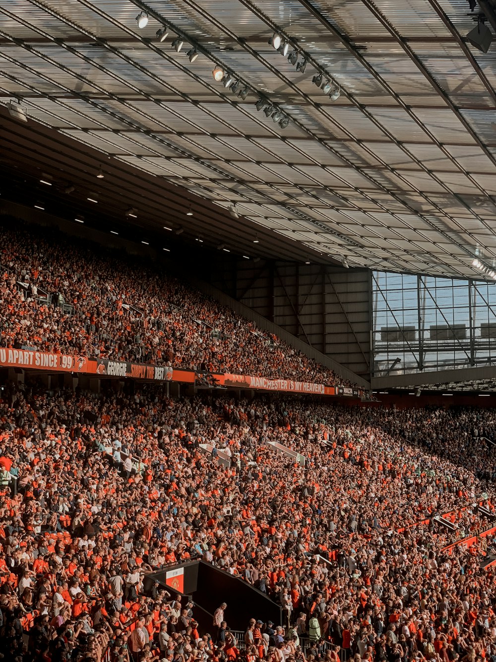 people sitting on red chairs inside stadium