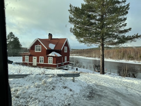 red and white house surrounded by snow covered ground