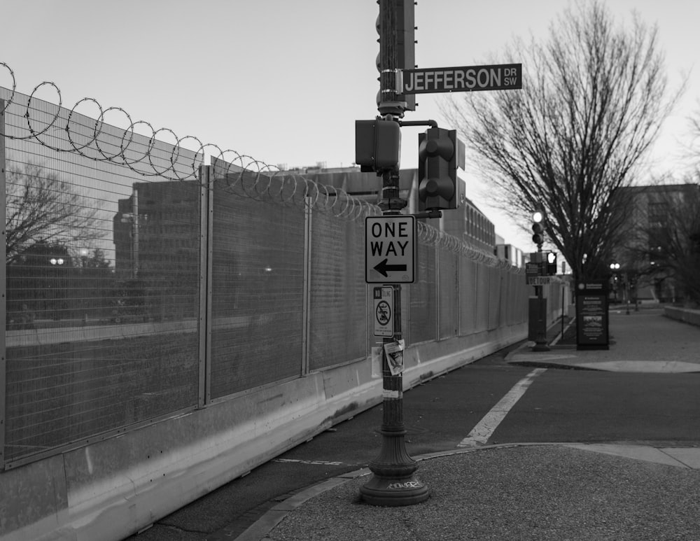 a black and white photo of a one way sign