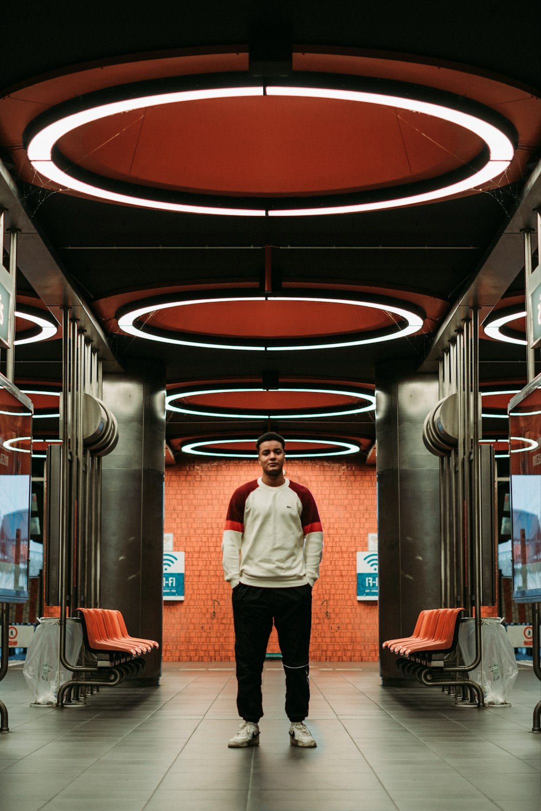 man in blue dress shirt and black pants standing on red and black hallway