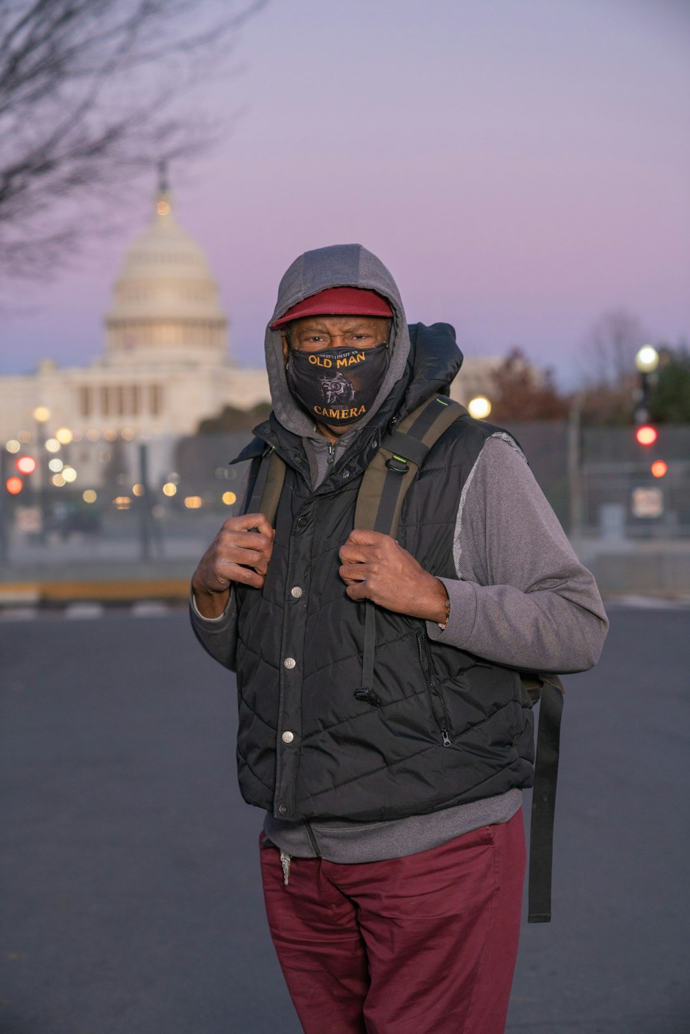 man in gray jacket and black and red backpack