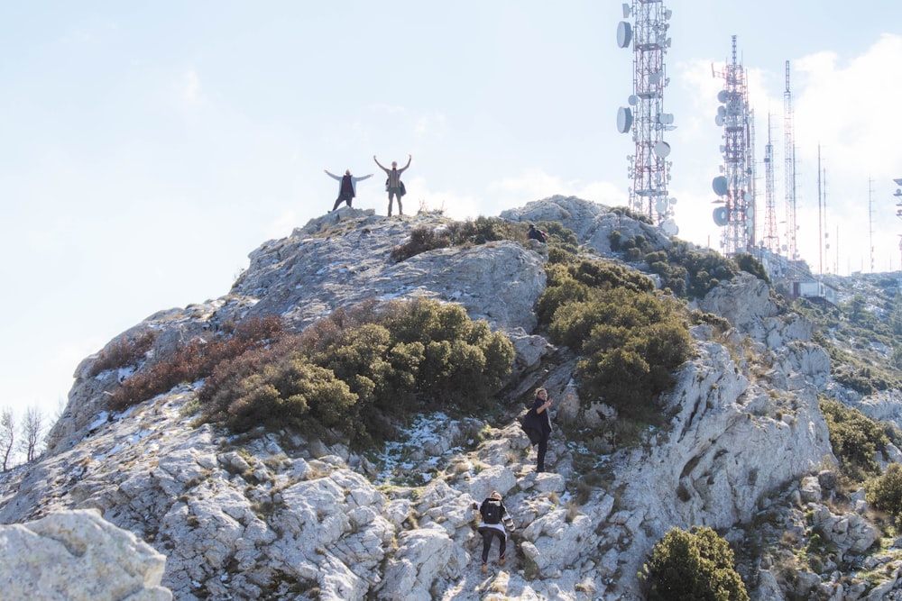 people on top of rocky mountain during daytime