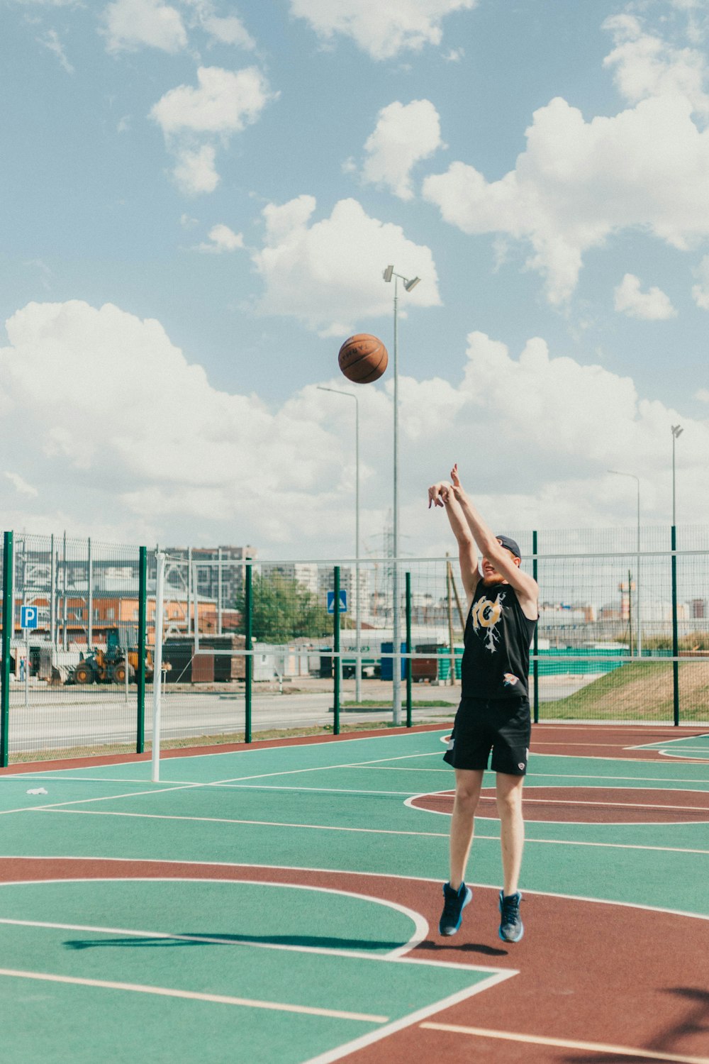 Mujer en mini vestido negro de pie en la cancha de baloncesto durante el día