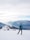 Woman with backpack pausing to admire a panoramic view of snow-capped Himalayan peaks