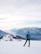 Man with backpack overlooking snow-capped Himalayan peaks.