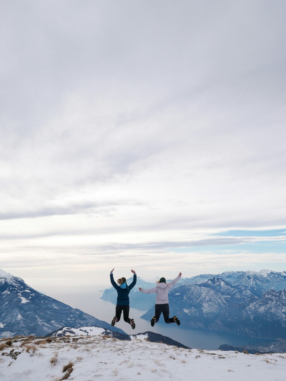 2 person standing on snow covered mountain during daytime