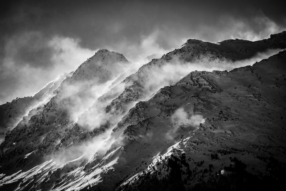 grayscale photo of mountain covered by clouds