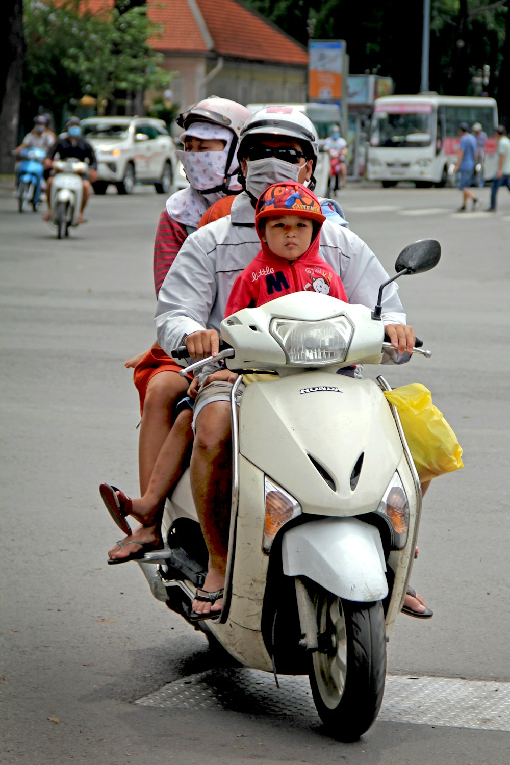 man in white long sleeve shirt and orange helmet riding white and red motor scooter on on on on on