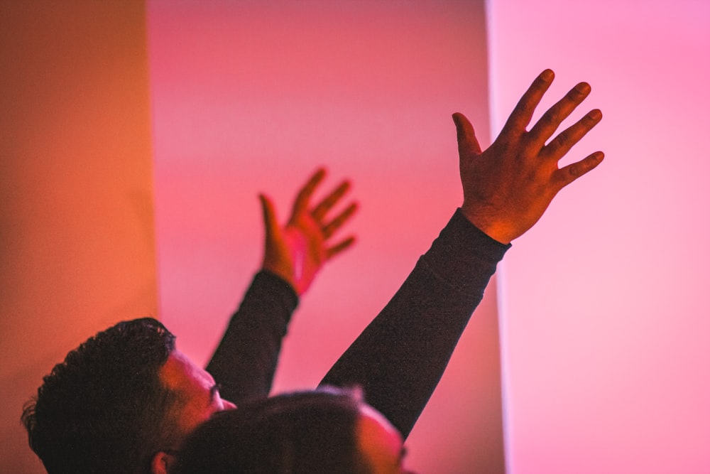 man in black long sleeve shirt raising his hand