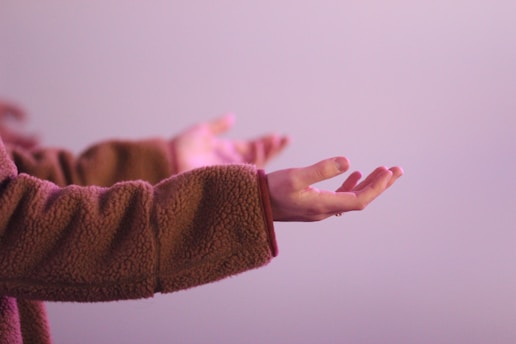 person in brown long sleeve shirt holding their arms out