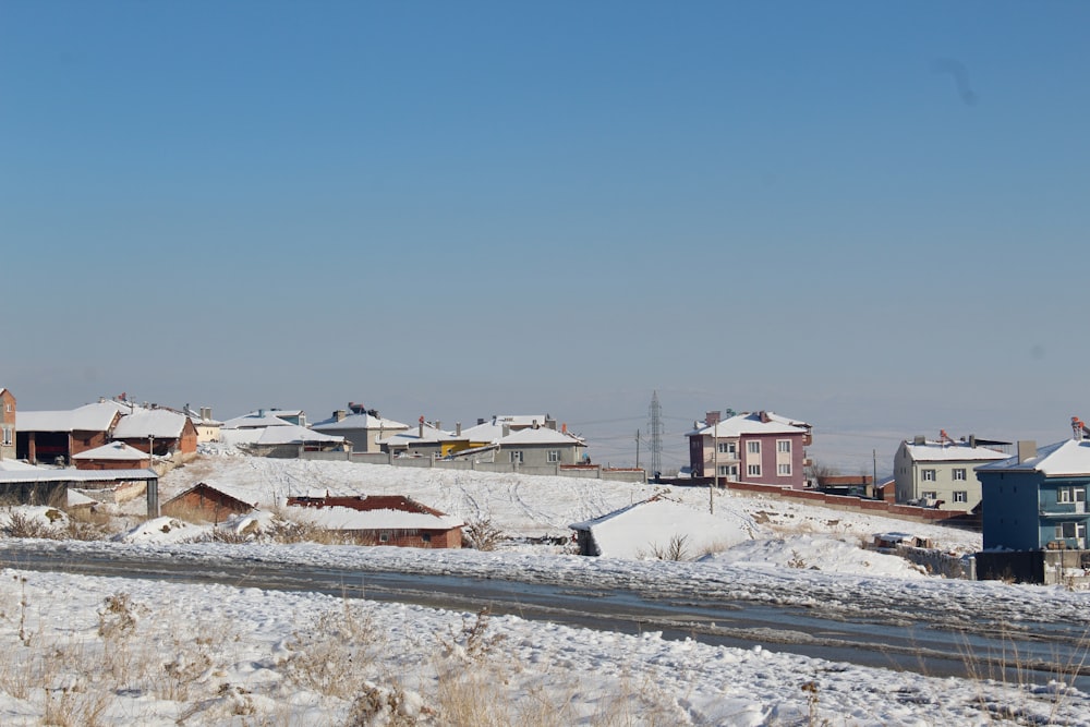 houses on snow covered field during daytime