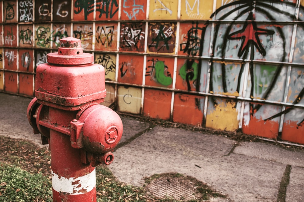 red fire hydrant beside brown brick wall