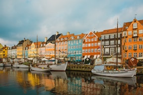 white boat on dock near buildings during daytime
