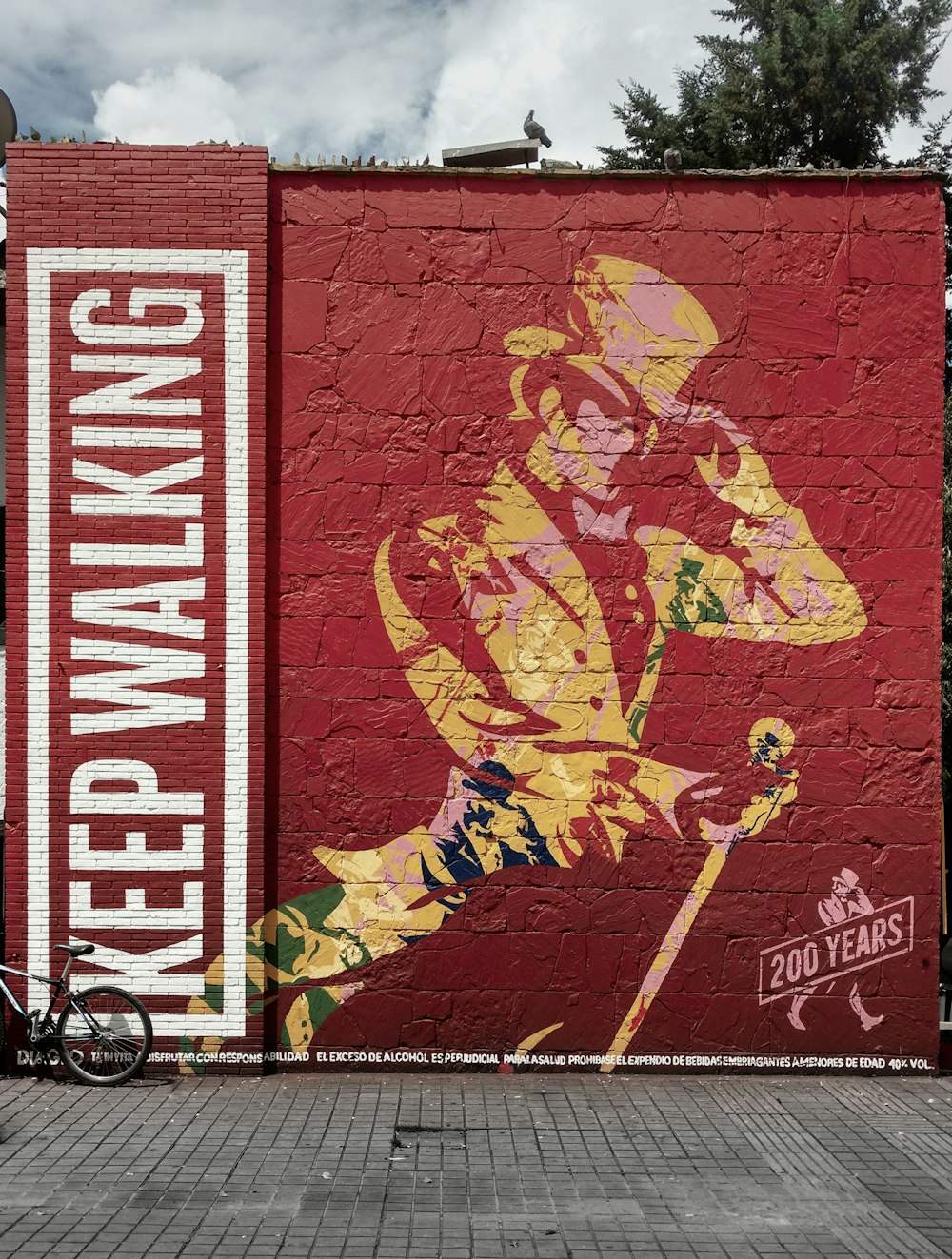 a red brick wall with a painting of a man holding a baseball bat