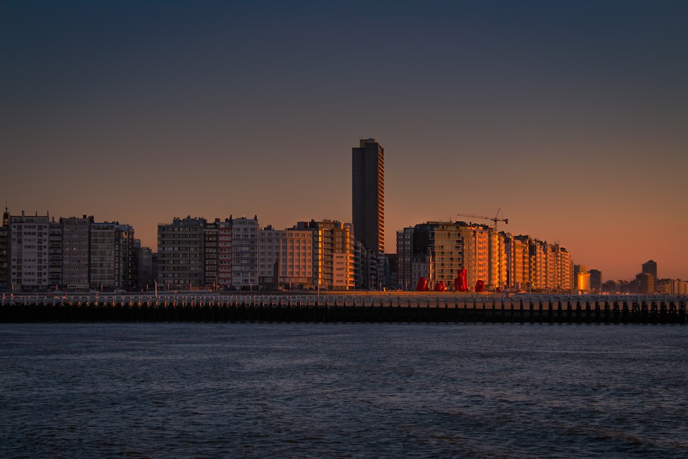 city skyline across body of water during sunset