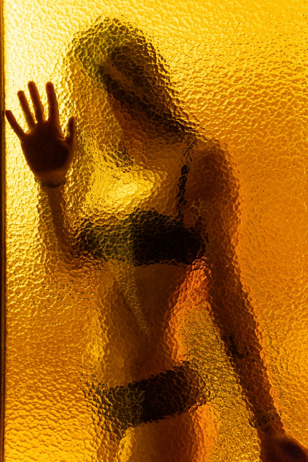 persons shadow on yellow wall