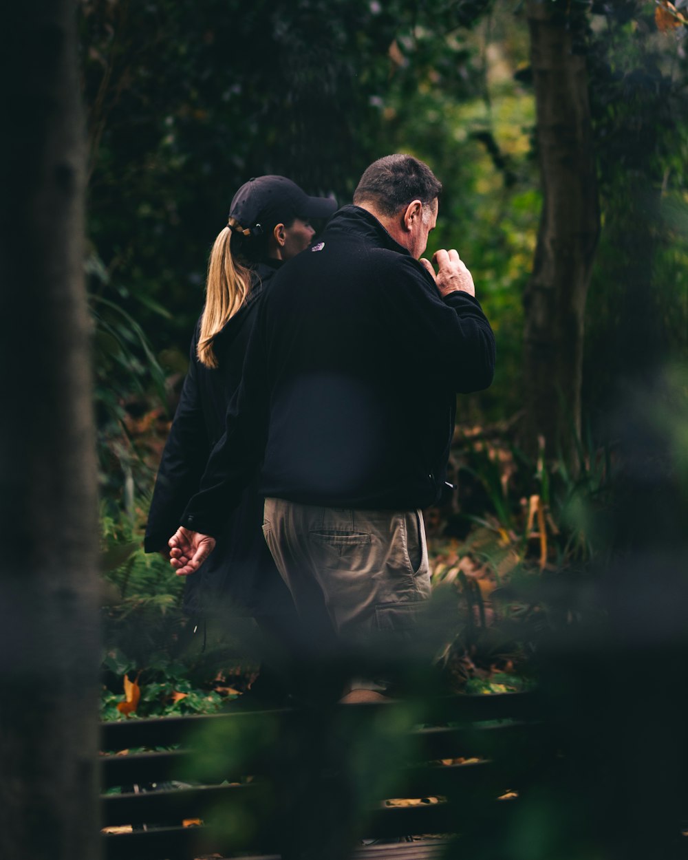 man in black jacket kissing woman in black jacket