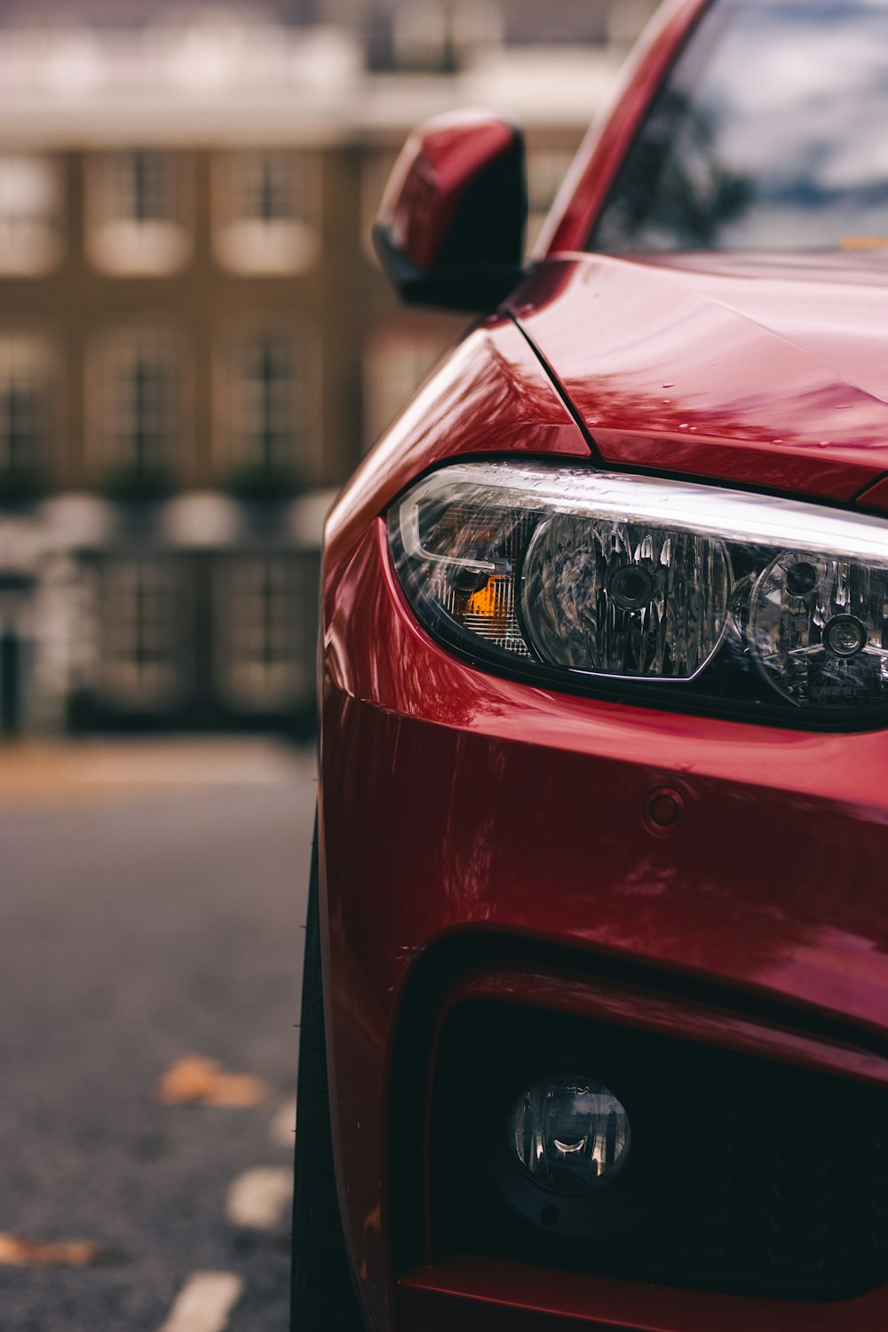 auto rossa davanti all'edificio durante il giorno