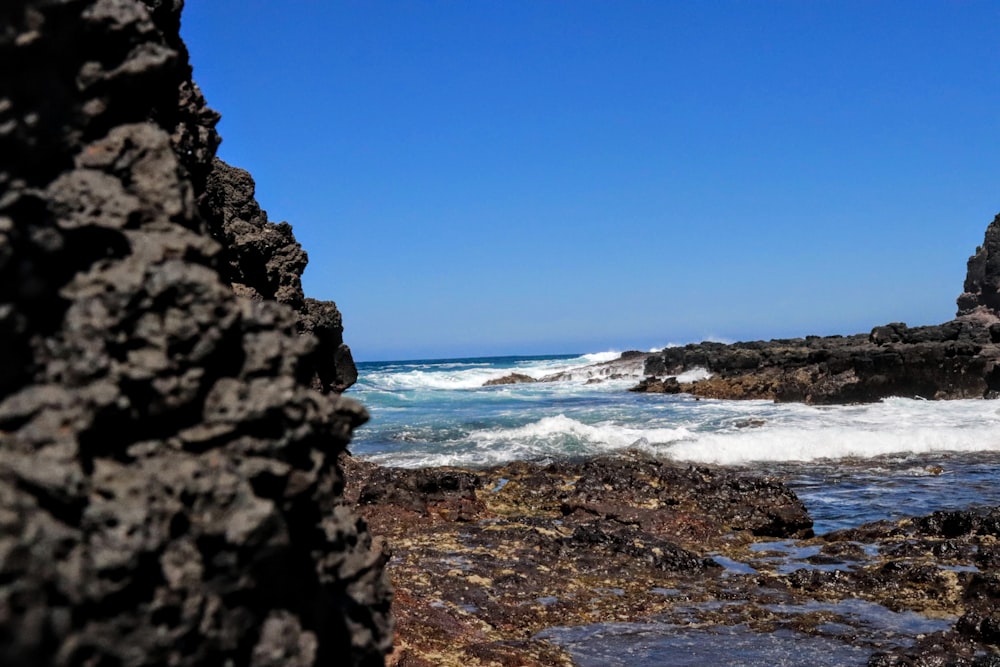 ocean waves crashing on rocky shore during daytime