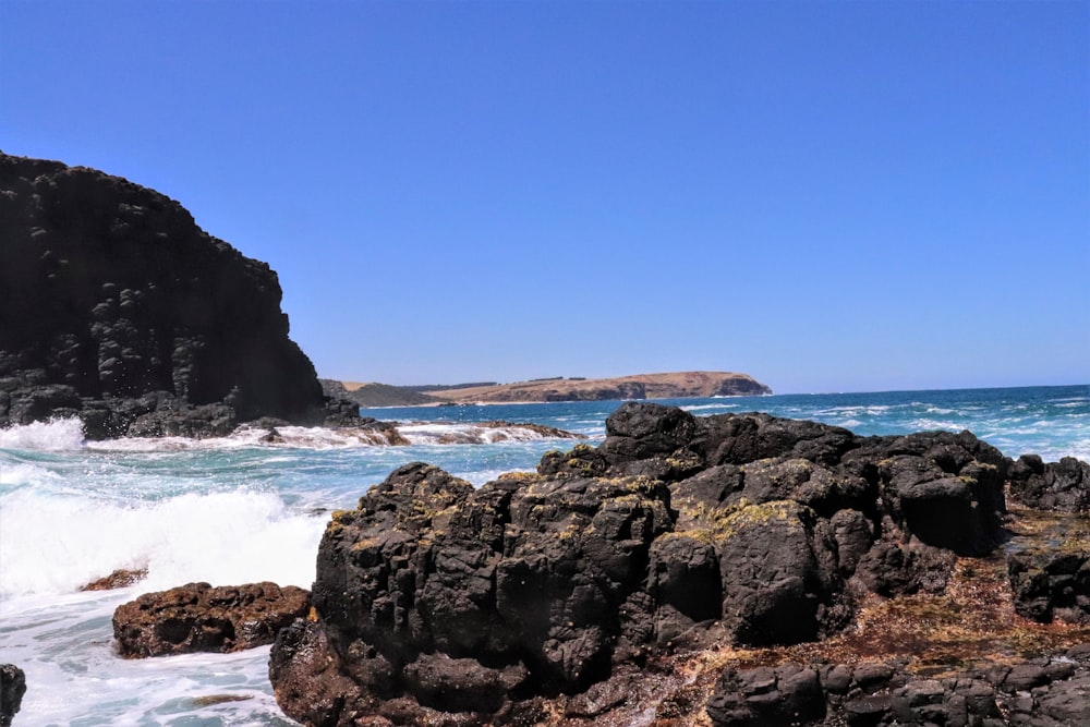 brown rock formation on sea during daytime