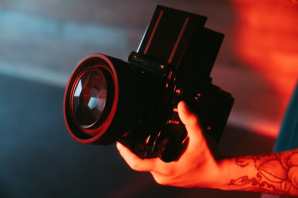 person holding black dslr camera