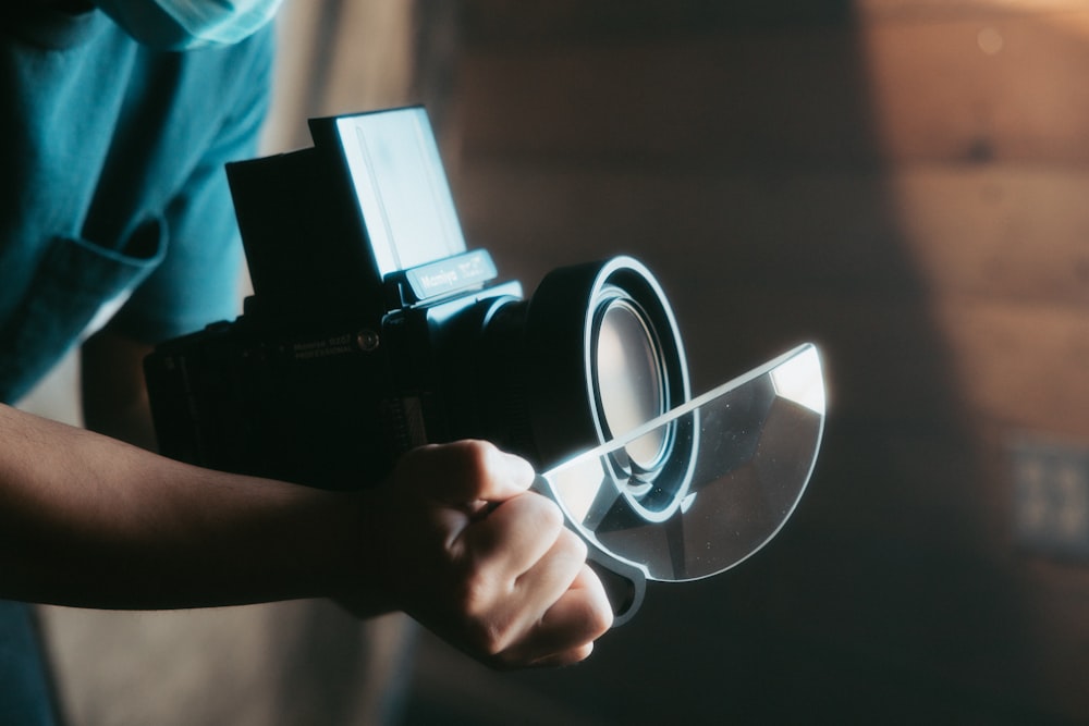 person holding black dslr camera