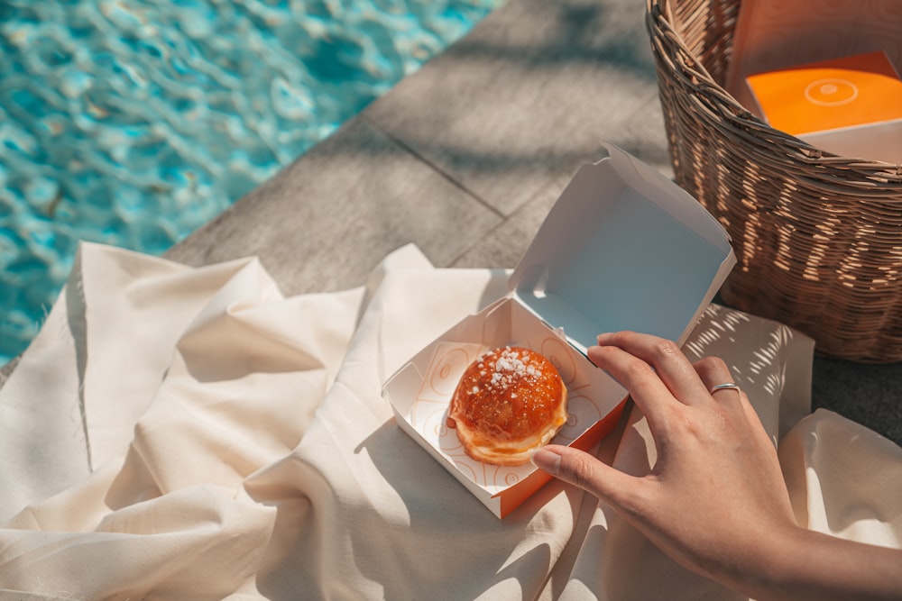 person holding a bread with red sauce