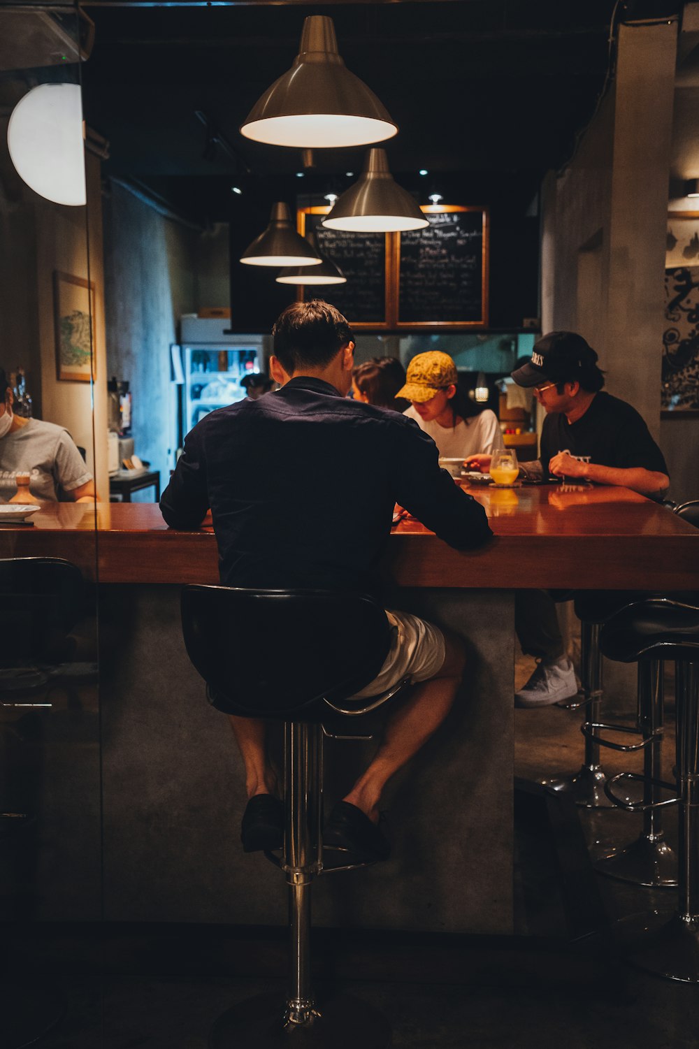 man in black t-shirt sitting on bar seat