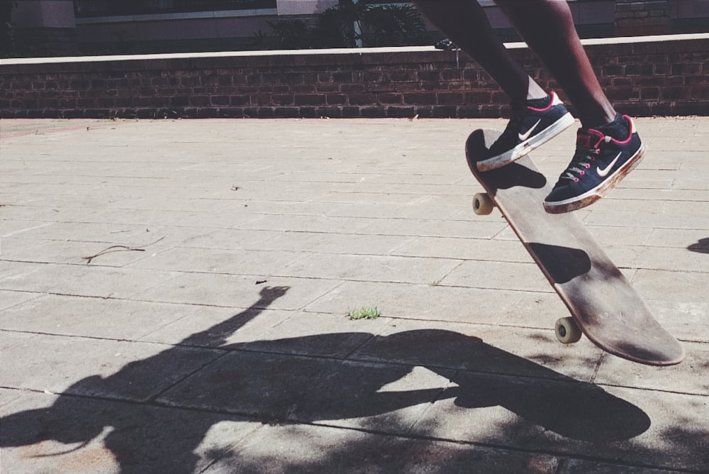 person in black pants and black and white nike sneakers