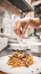 person holding white ceramic plate with food