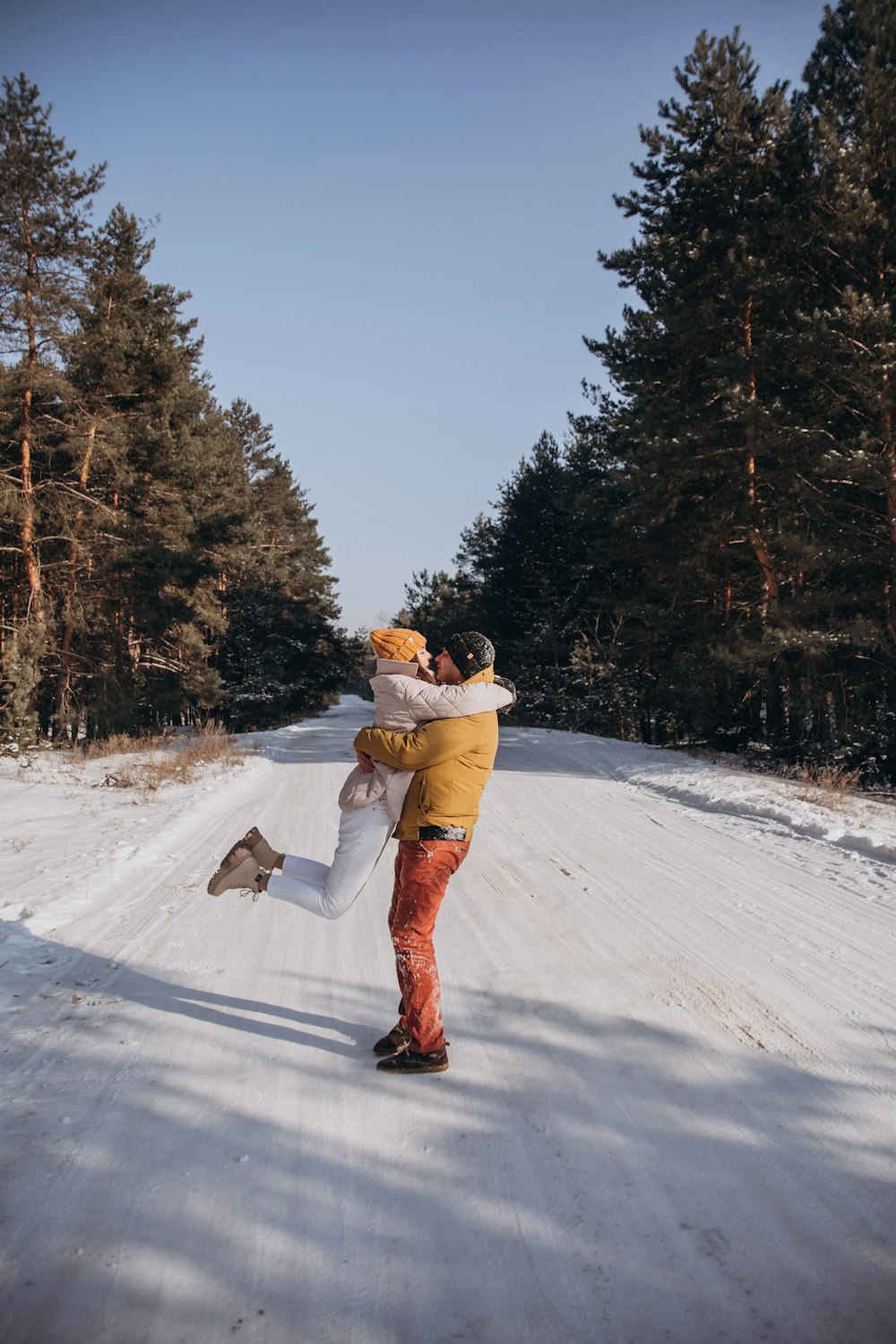 man in brown jacket and brown pants standing on snow covered ground during daytime