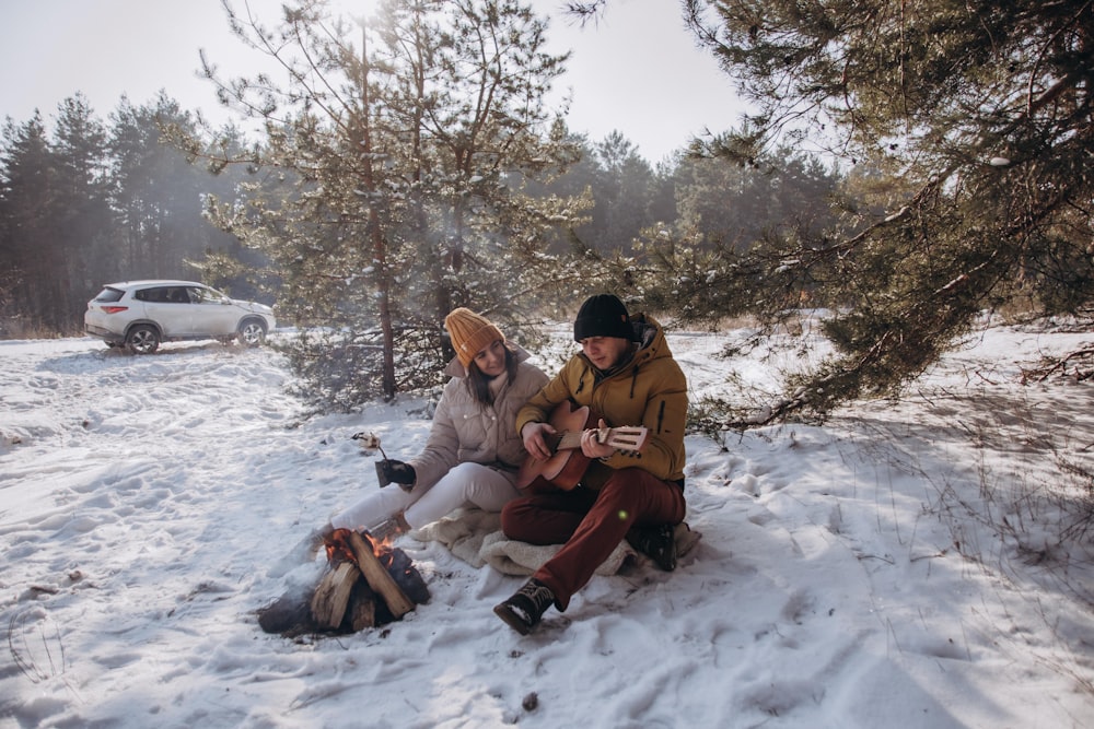 3 women sitting on snow covered ground during daytime