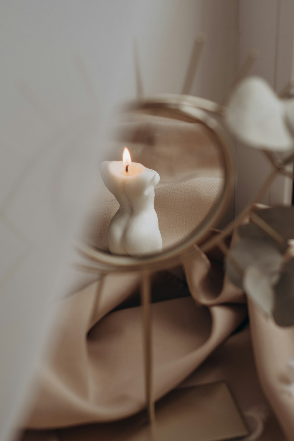 white candle on white ceramic candle holder