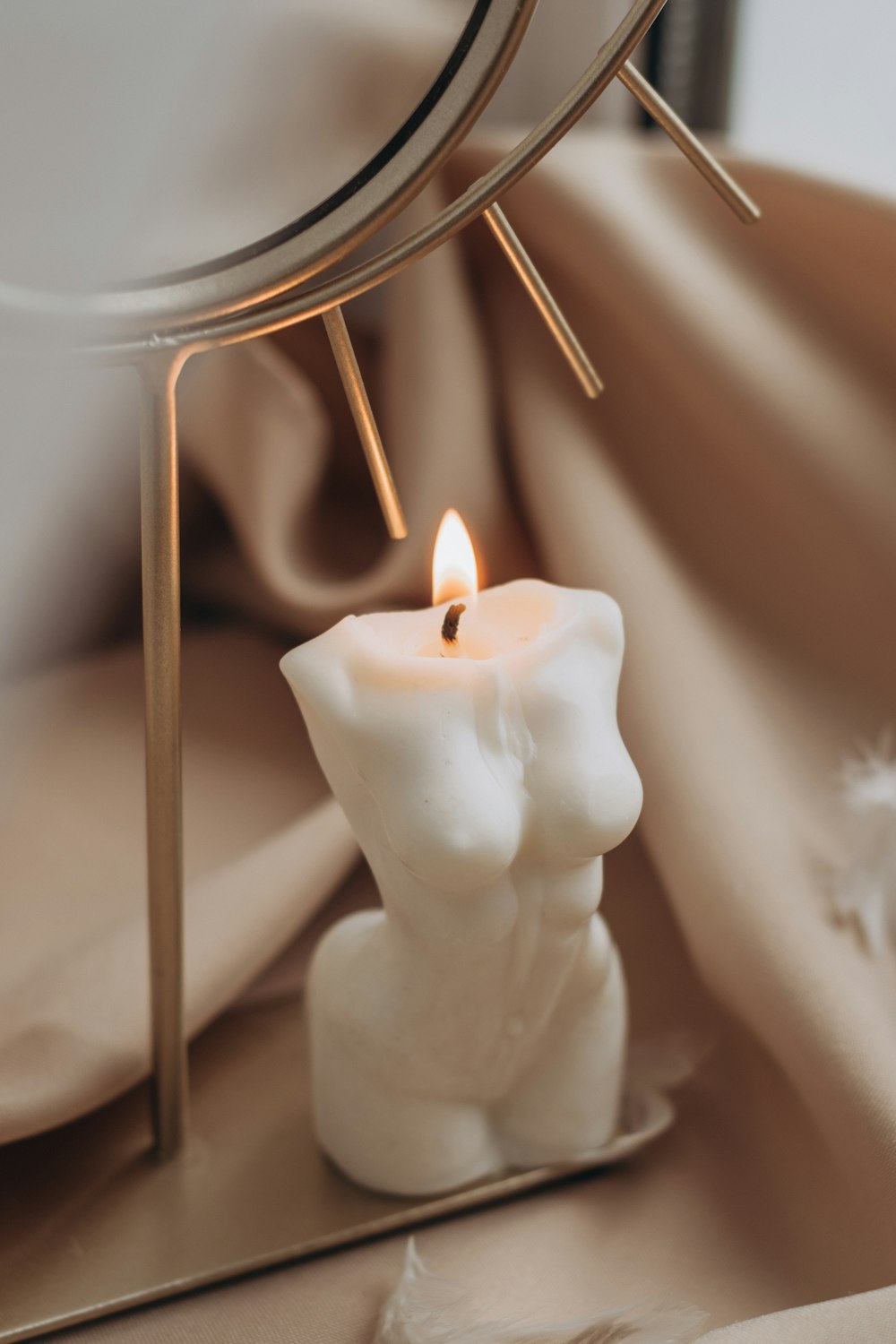 white pillar candle on white ceramic candle holder