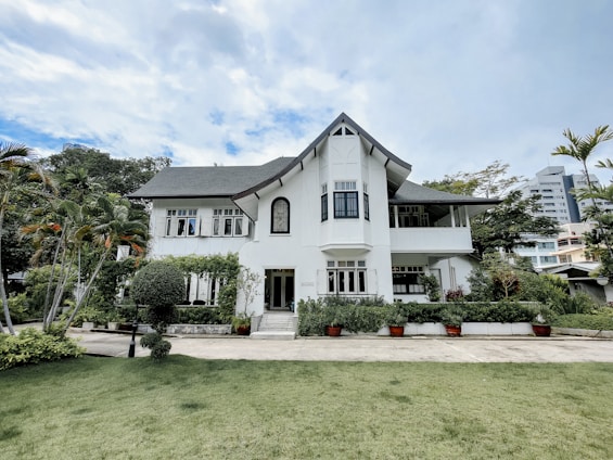 Elegant residential home with large windows and landscaped garden under a clear blue sky