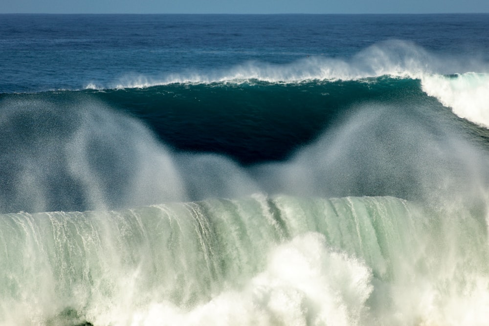 water falls on blue ocean water during daytime