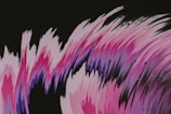 Abstract art featuring dynamic, sweeping brush strokes in shades of pink, purple, and black with a few scattered droplets.