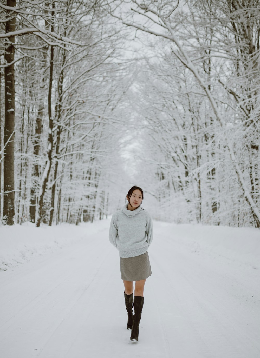 woman in white jacket standing on snow covered ground during daytime