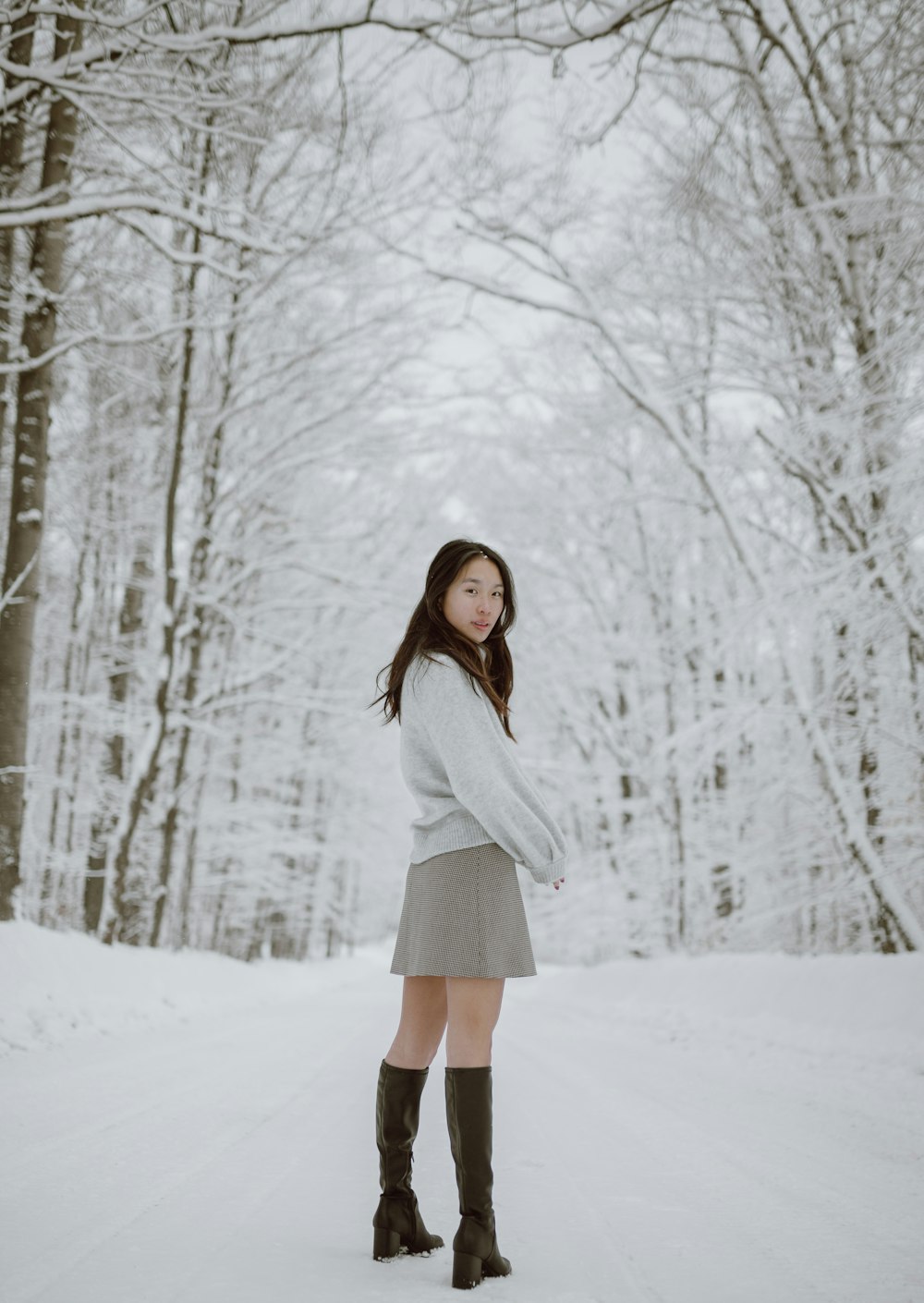 woman in white long sleeve shirt standing on snow covered ground