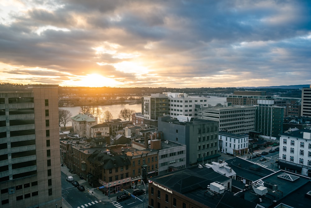 edifícios da cidade sob o céu nublado durante o pôr do sol