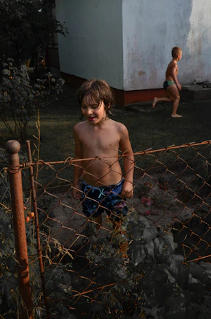 A candid shot of children playing in a sun-drenched garden with warm, natural tones.