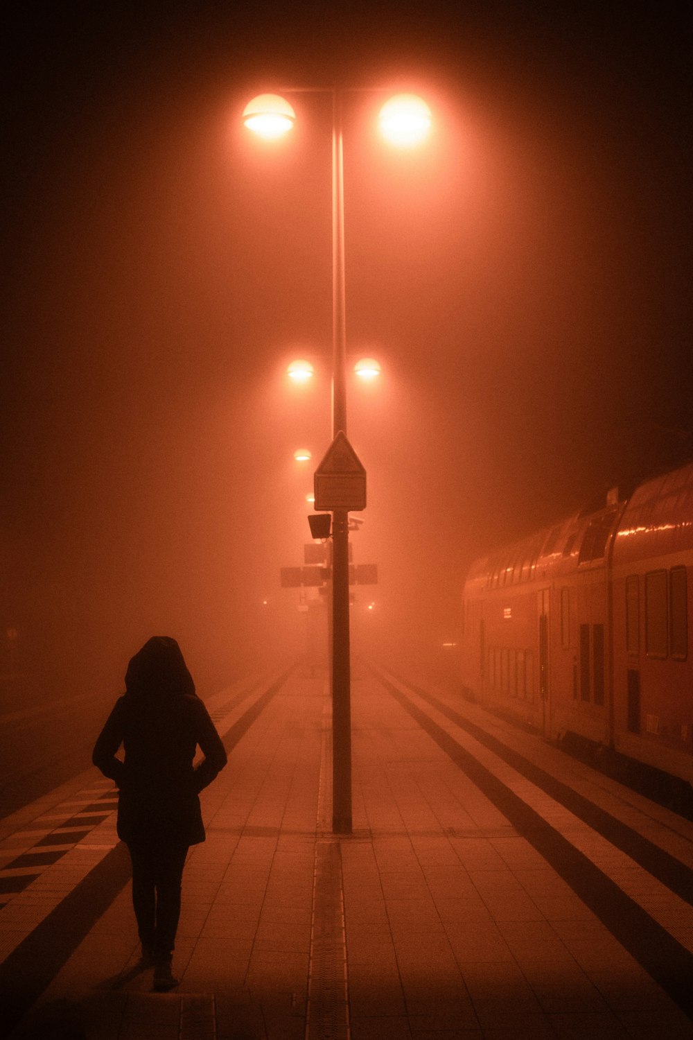 Hombre con chaqueta negra de pie cerca del tren durante la noche