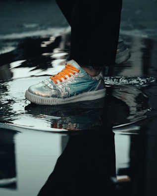 person in black pants wearing gray and orange nike sneakers