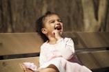 A candid photo of a toddler laughing while playing in a sunlit park.