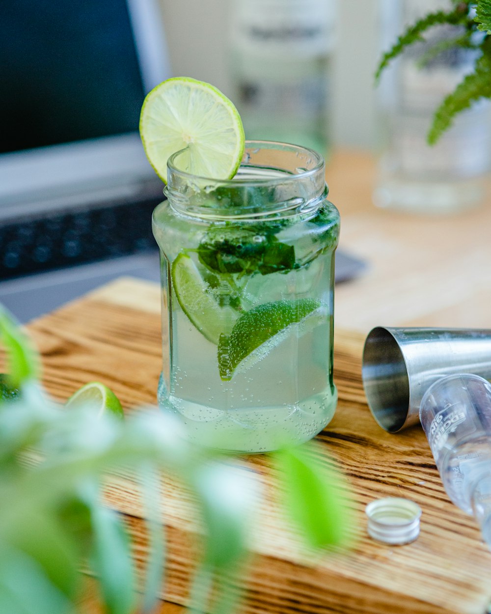 clear glass jar with green liquid and sliced lemon