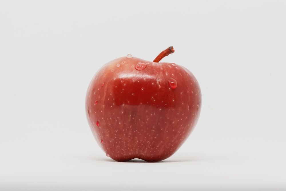 mela rossa su superficie bianca