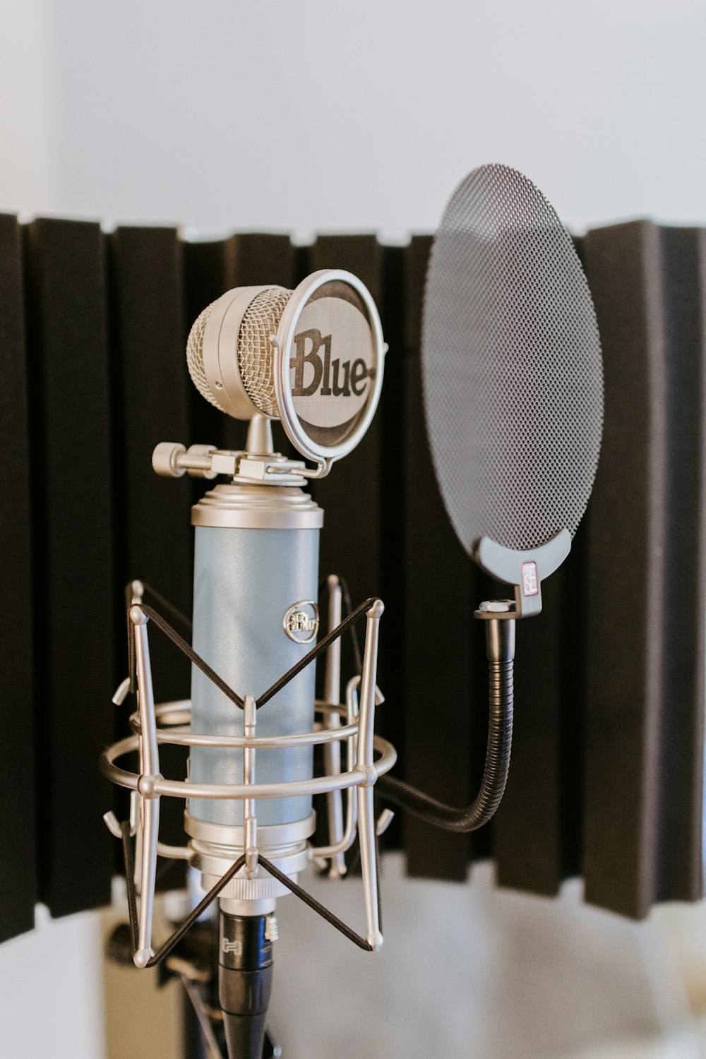 Micrófono plateado y negro en soporte de micrófono negro y plateado